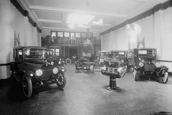 Automobiles on Display in Tent Under American Flag Banners - Art Print