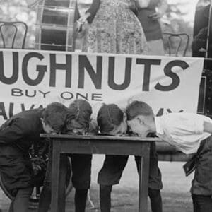 Boys Chow Down on a Table in a Donut Eating Contest - Art Print