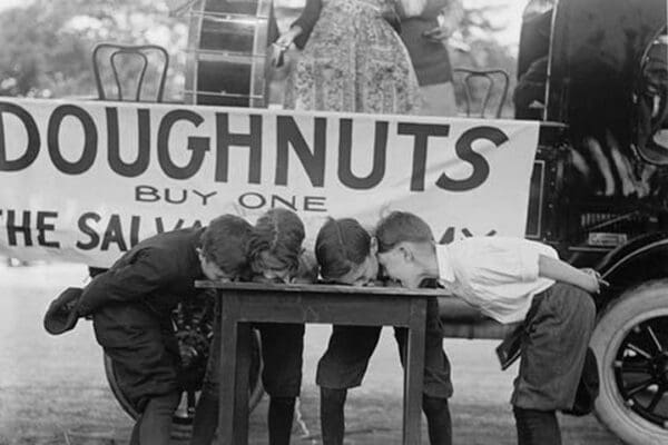 Boys Chow Down on a Table in a Donut Eating Contest - Art Print