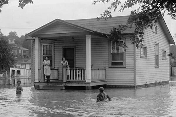 Children on porch of house surrounded by flood - Art Print