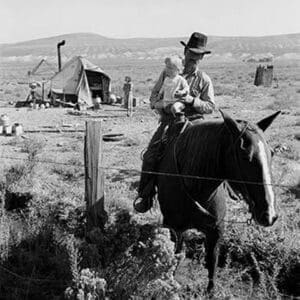 Cowboy holds his baby while riding a horse by Dorothea Lange - Art Print