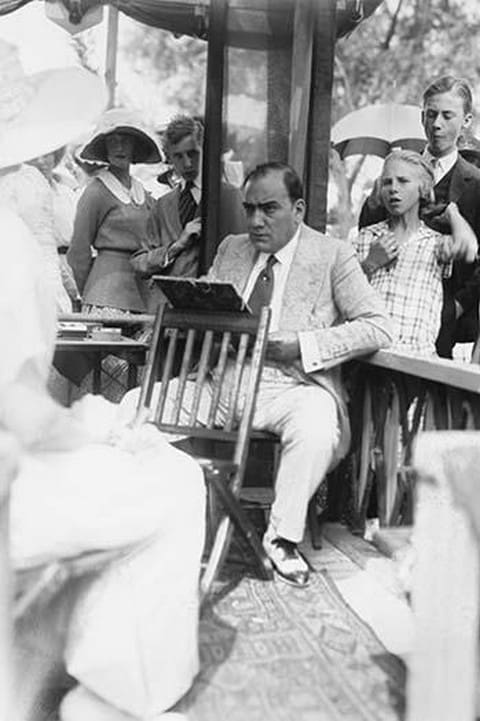 Enrico Caruso Leans back on chair holding a Board with Music - Art Print