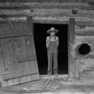 Farm boy in doorway of tobacco barn by Dorothea Lange - Art Print