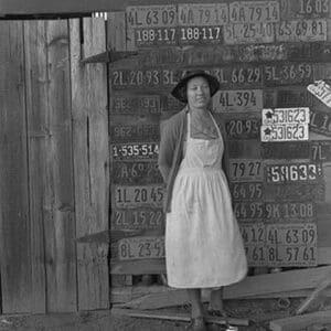 Farm woman beside her barn door by Dorothea Lange - Art Print