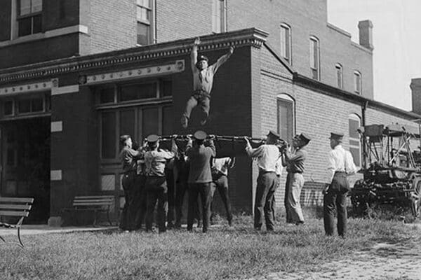 Firefighter Jumps into Net Held by Fellow Firemen - Art Print