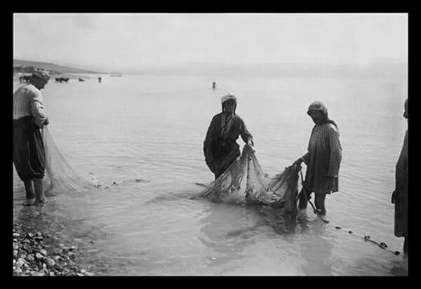 Fisherman Toiling with the Nets on the Sea of Galilee by American Colony in Jerusalem Photograhic Department - Art Print