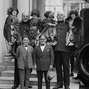 Little People all dressed in their finery are lifted in the arms of full sized people. - Art Print