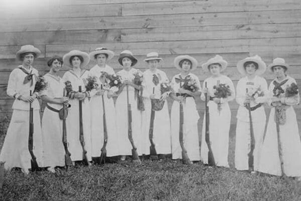 Nemours Women's Trap shooting Club in elegant dress hold both nosegays and rifles. - Art Print