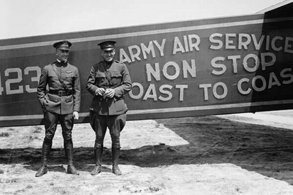 Pilots pose in front of a Plane that they fly coast to coast - Art Print