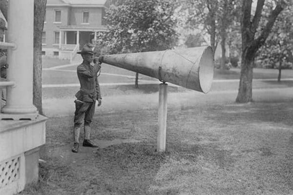 Soldier Plays his bugle into a huge megaphone at Fort Totten