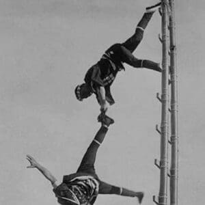 Two Tokyo Firefighters display acrobatic skill on very high bamboo ladders - Art Print