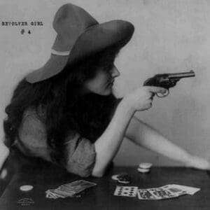 Young Cowgirl Hold Pistol Over a table of Playing Cards - Art Print